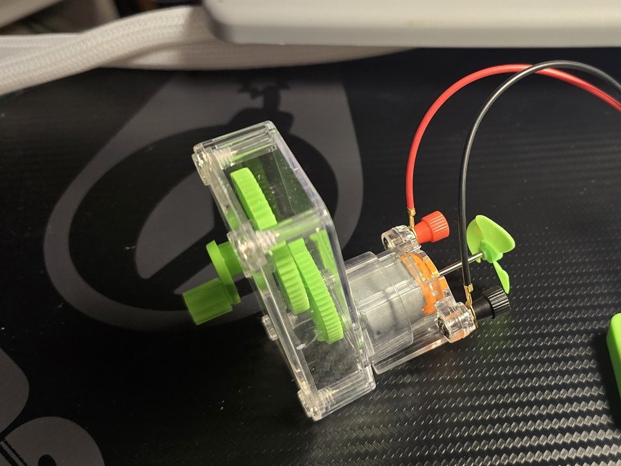 Hand-crank generator with transparent gearbox and green gears